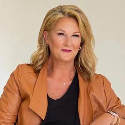 A woman in brown jacket posing for the camera.